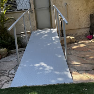 רמפה מתכתית עם מעקה ליד דלת כניסה