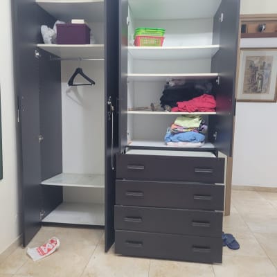 ארון פתוח עם בגדים ומדפים ריקים