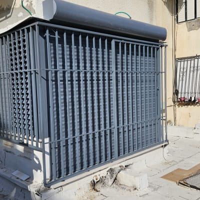 סורגים אפורים על חלון במבנה חיצוני