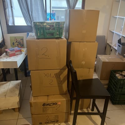 קופסאות קרטון ארוזות בחדר עם כיסא