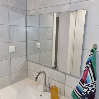 כיור עם ברז, מראה ומגבת צבעונית בחדר אמבטיה