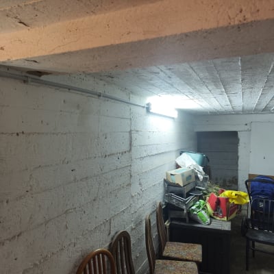 תאורת פלורסנט מותקנת על קיר בטון עם חיווט חשמלי.