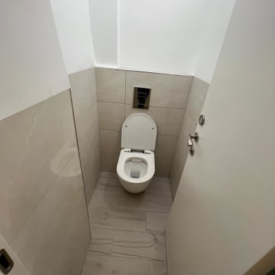 אסלה מותקנת בחדר שירותים עם אריחים חדשים