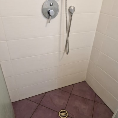 מקלחת עם אריחים סגולים וראש מקלחת מתכתי