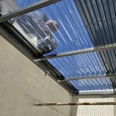 מסגרת מתכת תומכת גג שקוף עם אדם עובד