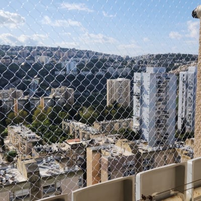 רשת הגנה על מרפסת עם נוף עירוני ברקע