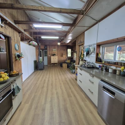 רצפת פרקט עץ בהירה במטבח כפרי עם קירות עץ.