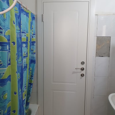 דלת לבנה עם ידית מתכת בחדר אמבטיה