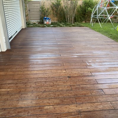 דק עץ חום בחצר עם דשא וצעצועים