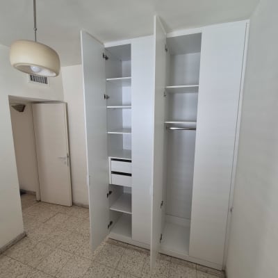 ארון פתוח עם מדפים ודלתות בחדר ריק