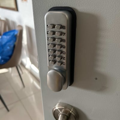 מנעול קוד מתכתי על דלת אפורה