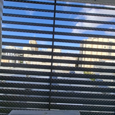 רשת יונים מותקנת על מרפסת עם נוף עירוני