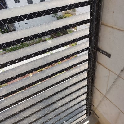 רשת מתכת מותקנת על חלון למניעת כניסת יונים