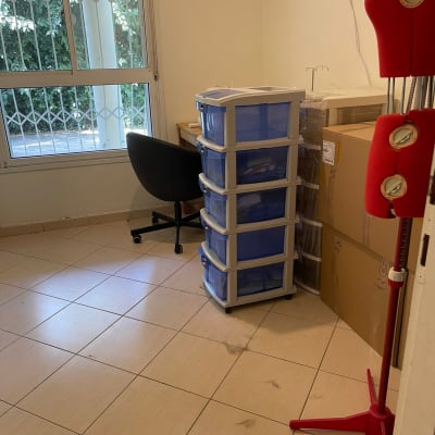 חדר עם ארגזי אחסון, כיסא ושולחן ליד חלון