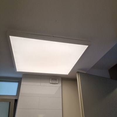 תאורת תקרה מרובעת דולקת בחדר עם שקע חשמלי