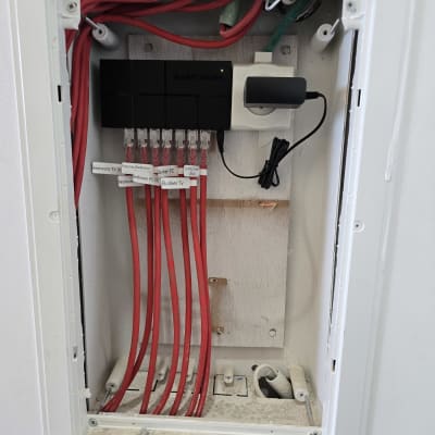 ארון תקשורת עם כבלים אדומים ומפצל רשת