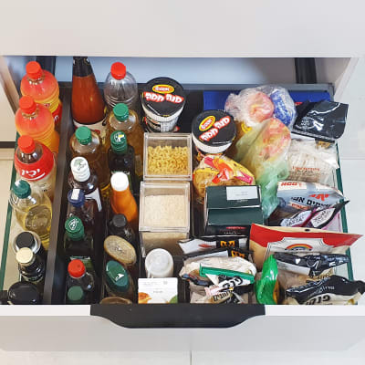 מגירת מטבח מאורגנת עם בקבוקים, קופסאות ותבלינים