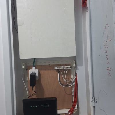 ארון תקשורת עם כבלים אדומים ושחור, נתב עם נורות ירוקות