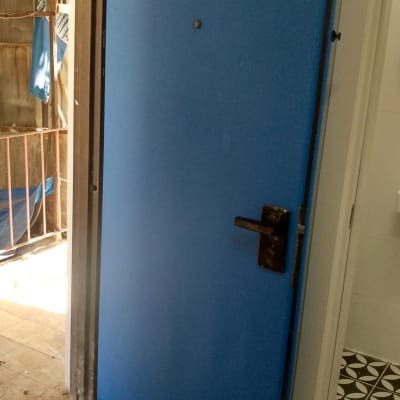 דלת כחולה עם ידית מתכת בחדר פנימי