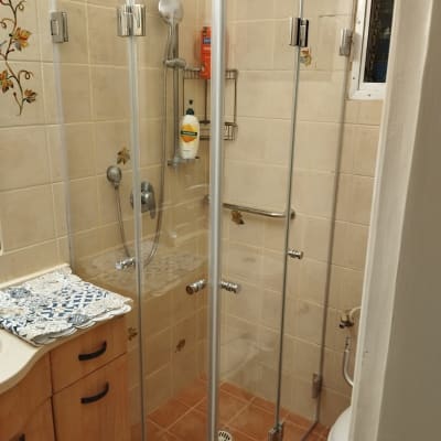 מקלחון זכוכית עם ראש מקלחת ומוצרי רחצה