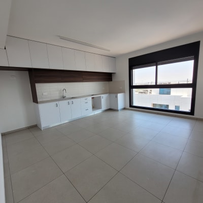 מטבח ריק עם ארונות וכיור, רצפה נקייה