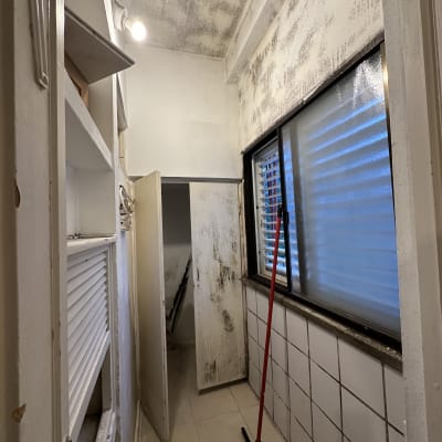 קירות עם סימני עובש, מטאטא עומד ליד חלון