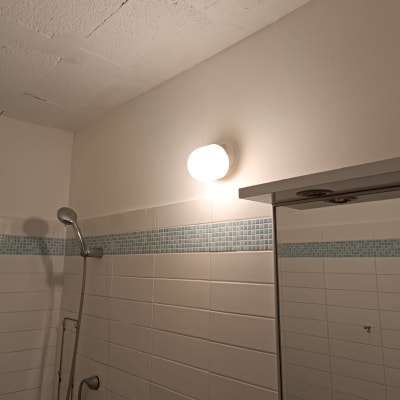 קיר צבוע בלבן עם מנורה עגולה