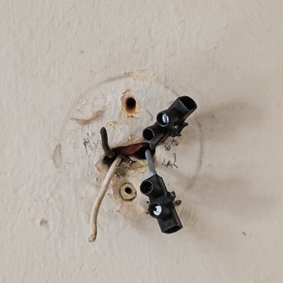 חוטי חשמל חשופים עם מחברים על קיר