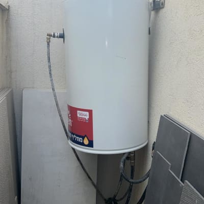 דוד שמש מותקן על קיר חיצוני עם צינורות מחוברים