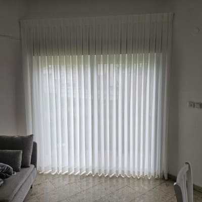 וילון לבן שקוף תלוי על חלון גדול