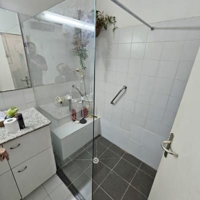 מקלחון זכוכית עם בקבוקי שמפו וסבון