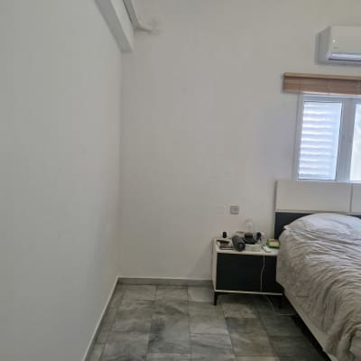 קיר לבן עם מזגן וחלון בחדר שינה