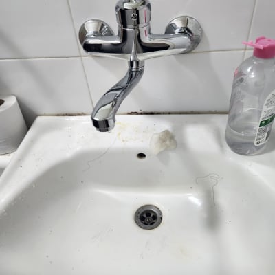 ברז כרום מעל כיור לבן עם סבון נוזלי