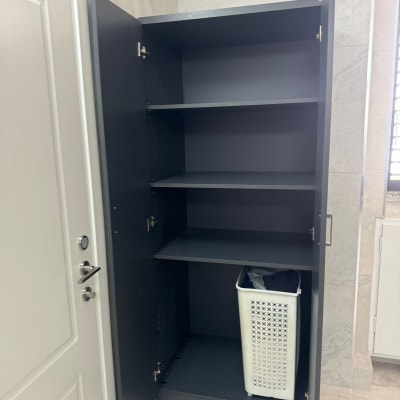 ארון פתוח עם מדפים וסל כביסה בפנים