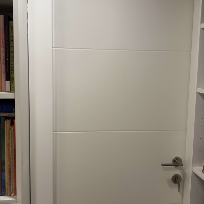 דלת לבנה עם ידית מתכת ומנעול