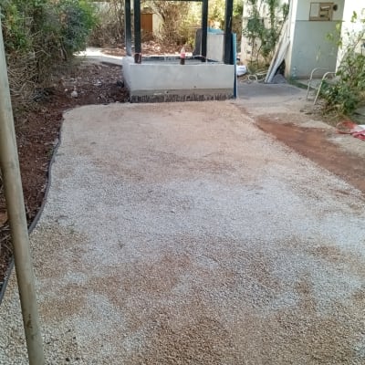 שביל חצץ בגינה עם צמחייה מסביב