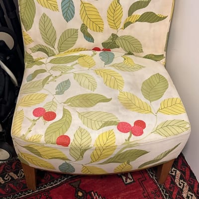 כיסא עם ריפוד עלים צבעוני על שטיח אדום