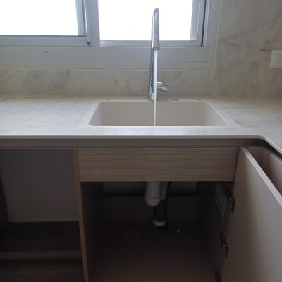 כיור מטבח עם ברז פתוח וצנרת גלויה מתחת