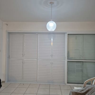 תריסי אלומיניום לבנים בחלון גדול