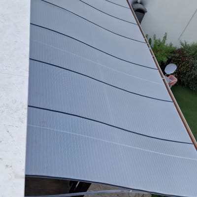 סוכך מותקן מעל מרפסת עם גינה למטה