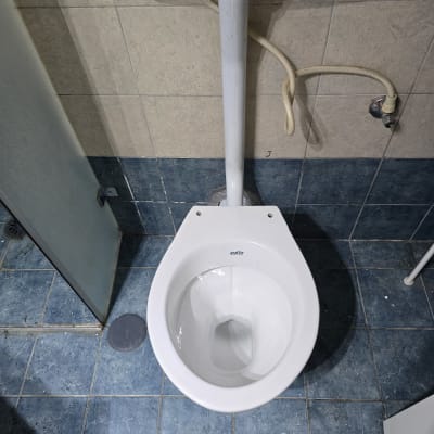 אסלה עם צינור מים מחובר לקיר