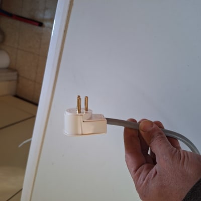 יד מחזיקה תקע חשמלי עם כבל אפור