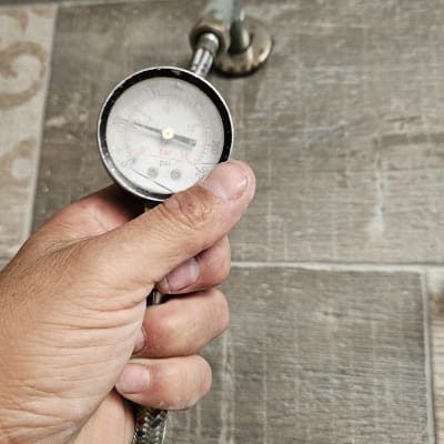 מד לחץ מים על רקע רצפת אריחים