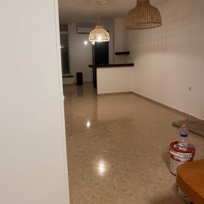 חדר ריק עם רצפת קרמיקה ודלי צבע