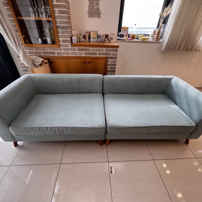 ספה ירוקה בחדר מגורים עם חלון ווילונות