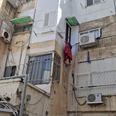 בניין עם מזגנים וחוטי חשמל חשופים