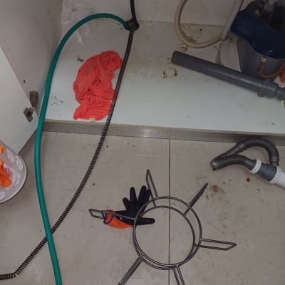 צינורות, כפפות וכלי עבודה מתחת לכיור