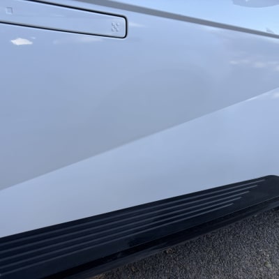 חלק צדדי של רכב לבן עם דלת וסף שחור