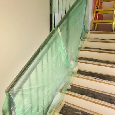 מעקה מדרגות מכוסה בניילון ירוק להגנה מצבע