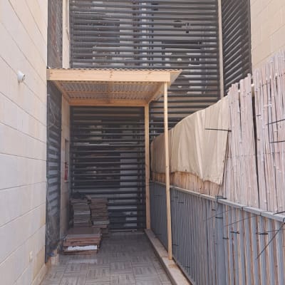 פרגולה מעץ עם גדר במרפסת מרוצפת